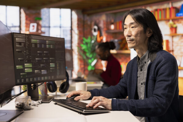 Senior technician coding advanced AI algorithm in startup office, refining machine learning models to enhance automation. Asian CTO manager using coding platform in Silicon Valley workplace, Salesforce Admin Training