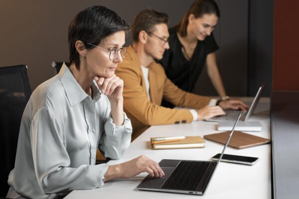 Three employees working at their laptop, Salesforce Certification Training
