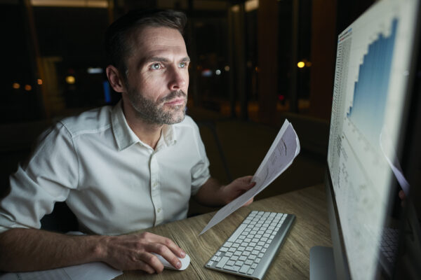 Focused man with document using computer, Salesforce Admin Course