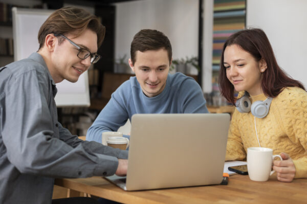 Three employees checking on the laptop, Salesforce Training Courses