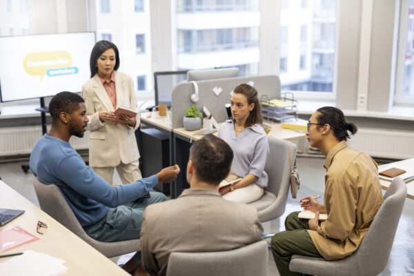 Group of diverse professionals participating in a conversation workshop in a modern office setting, discussing communication skills and team collaboration strategies. Salesforce Developer Course in New York