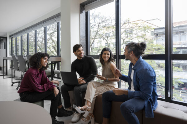 Young professionals having a collaborative meeting in a modern office with laptops, discussing Salesforce Developer Course in New York